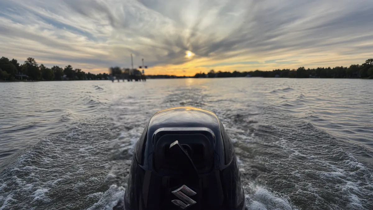 Abendfahrt: Blick vom Heck über den Außenborder in den Sonnenuntergang (Ränder mit KI ergänzt)