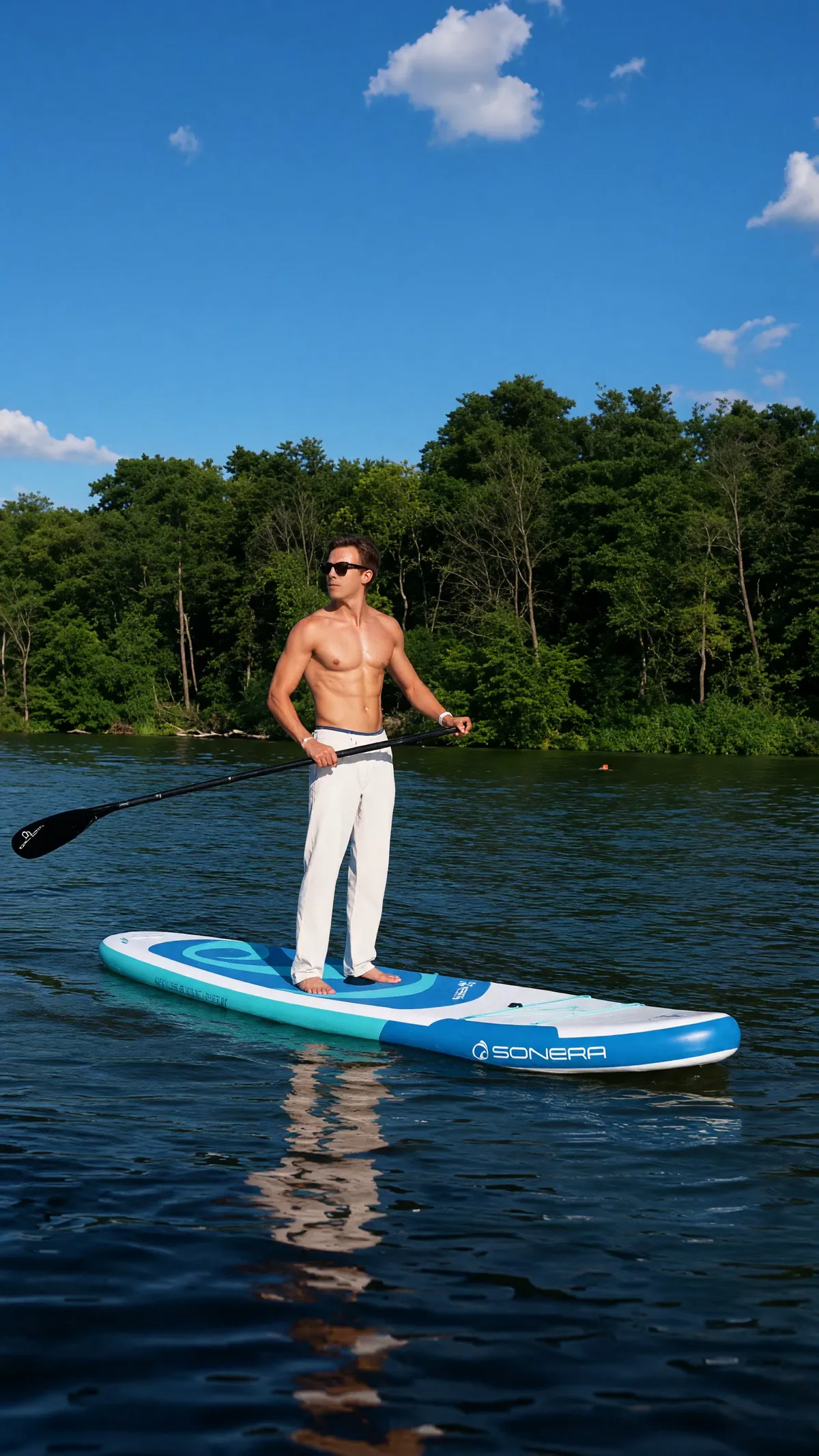 Stehend auf dem SUP-Board vor bewaldetem Ufer (Foto mit KI nachgeschärft)